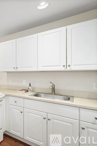 A kitchen with white cabinets and a sink.