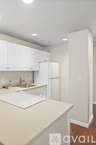 A kitchen with white cabinets and a white fridge.