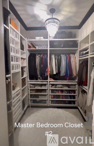 A large, organized closet with a chandelier hanging from the ceiling.