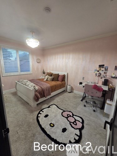 A bedroom with a bed, desk, and chair.