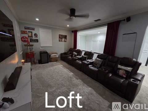 A living room with a large couch and a ceiling fan.