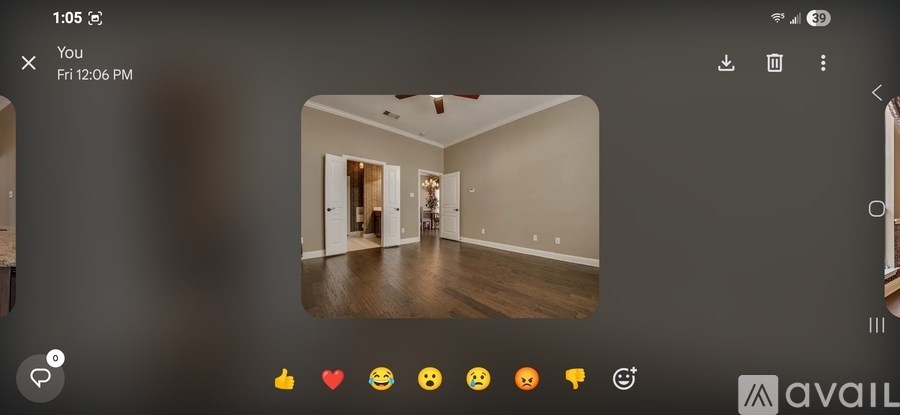 A room with wooden floors and a doorway leading to another room.