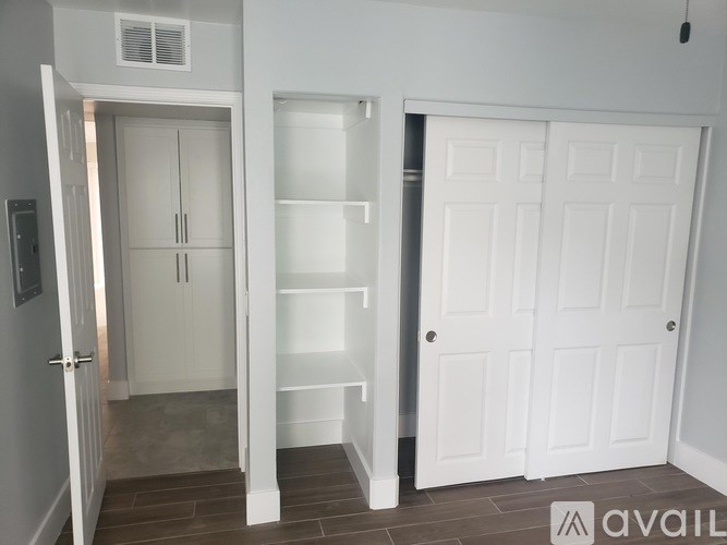 A white door with a shelf underneath it.