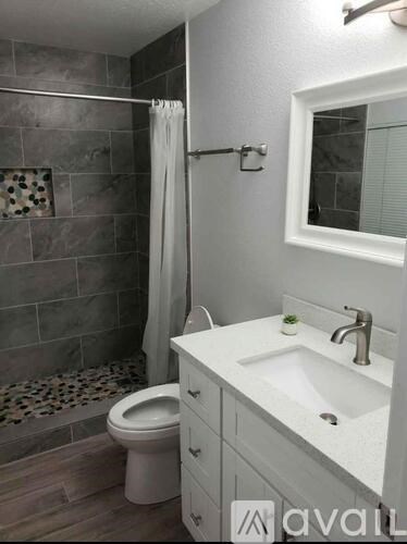 A bathroom with a toilet, sink, and shower.