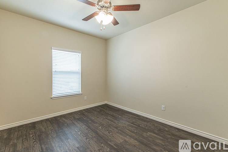 A room with a ceiling fan and a window with blinds.