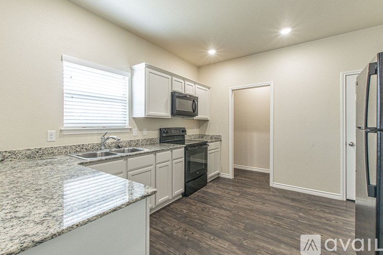 A kitchen with granite countertops and white cabinets.