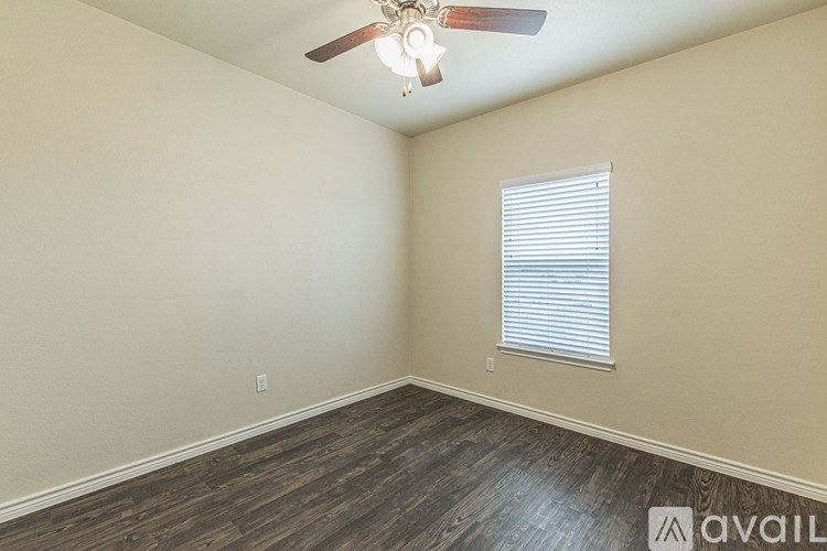 A room with a ceiling fan and a window with blinds.