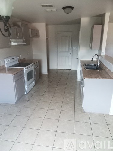 A kitchen with white appliances and a white door.