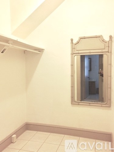 A bathroom with a mirror and a toilet paper roll on the floor.