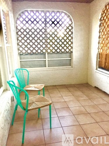 A chair and a table are in a room with a window.