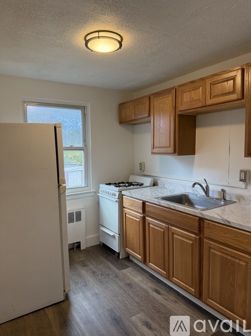A kitchen with wooden cabinets and a white refrigerator.
