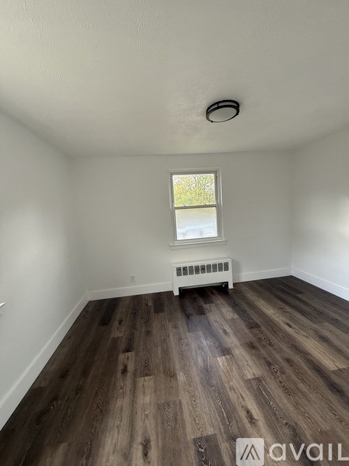 A room with a window and a radiator on the floor.