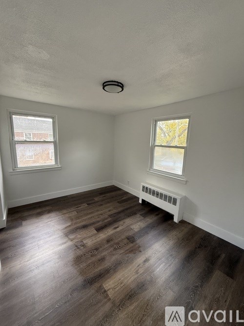 A room with wooden floors and a window with a white frame.