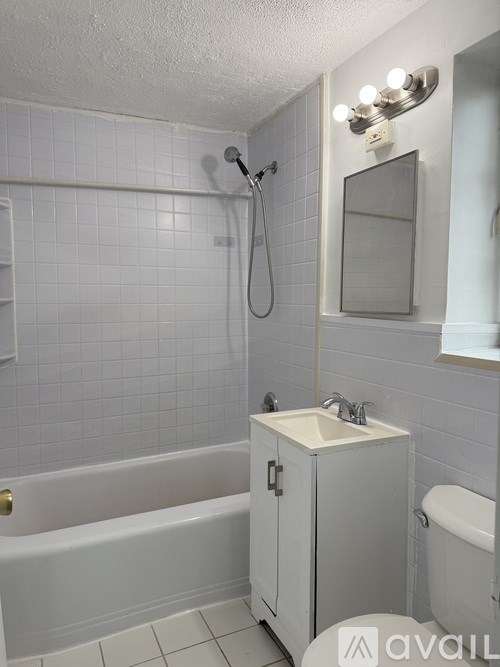 A white bathroom with a tub, sink, and toilet.