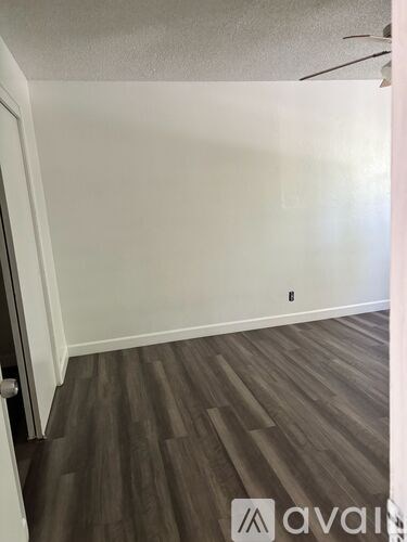 A room with wooden flooring and a ceiling fan.