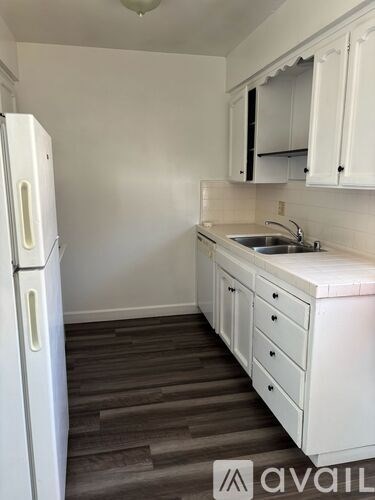 A kitchen with white appliances and cabinets.