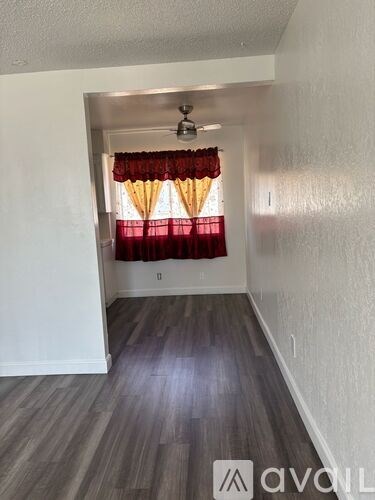 A room with a window covered by red curtains.