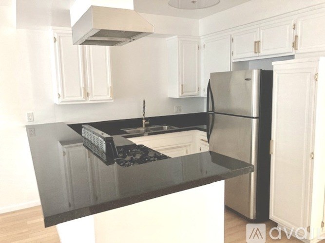 A kitchen with a black countertop and white cabinets.