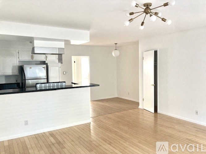 A kitchen with a white counter and a stove top oven.
