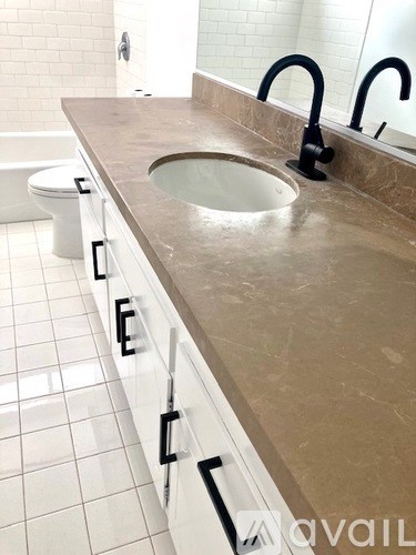 A bathroom with a sink, toilet and a mirror.