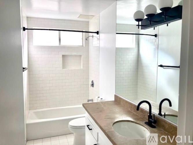 A bathroom with a white toilet and a white bathtub.