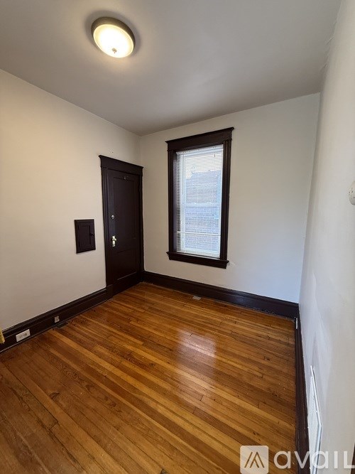 A room with wooden floors and a window with blinds.
