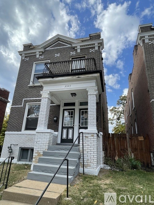 A two-story house with a black door and white trim.