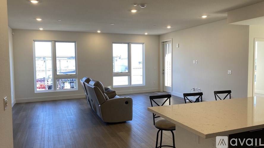 A spacious room with a long table and chairs, and a couch.