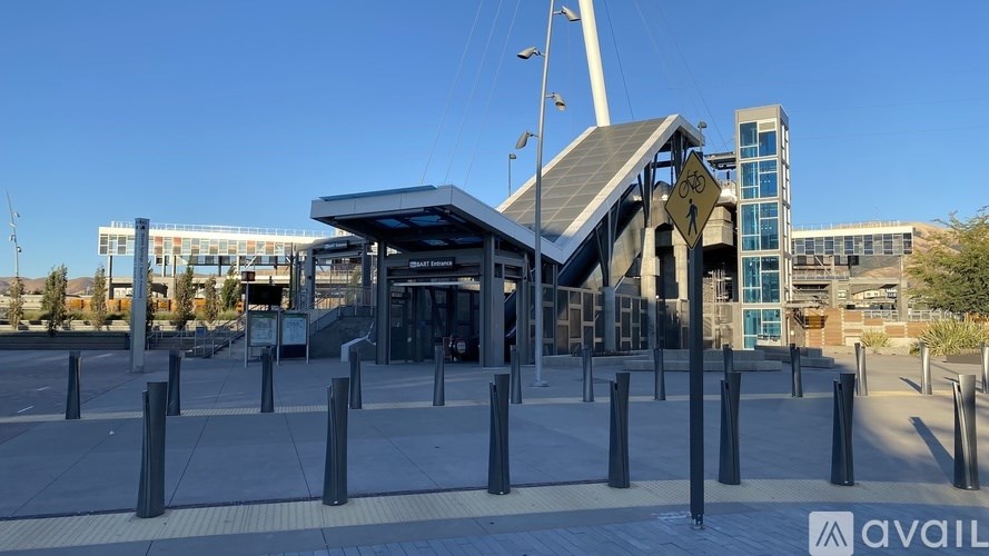 A modern building with a glass facade and a large entrance with a canopy.