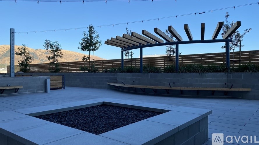 A patio area with a fire pit and a pergola.