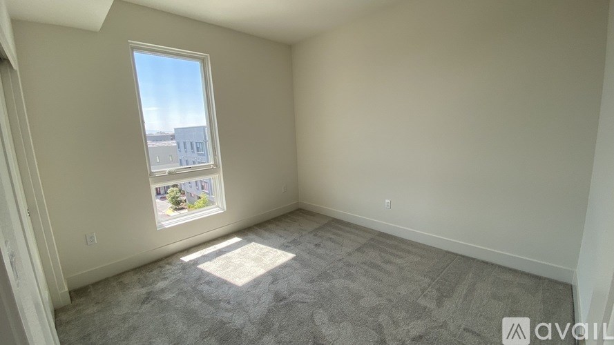 A room with a window showing a view of buildings outside.