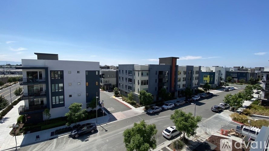 A modern apartment complex with a parking lot in front.