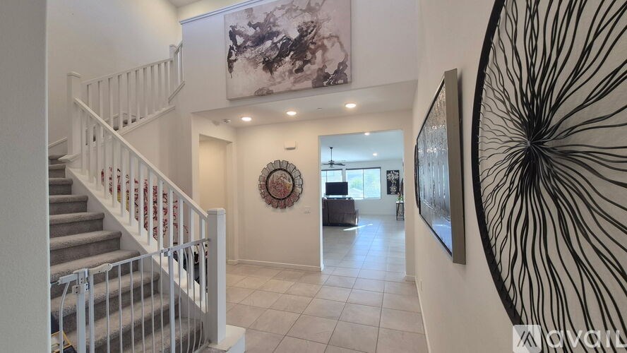 A staircase with a white railing and a clock on the wall.