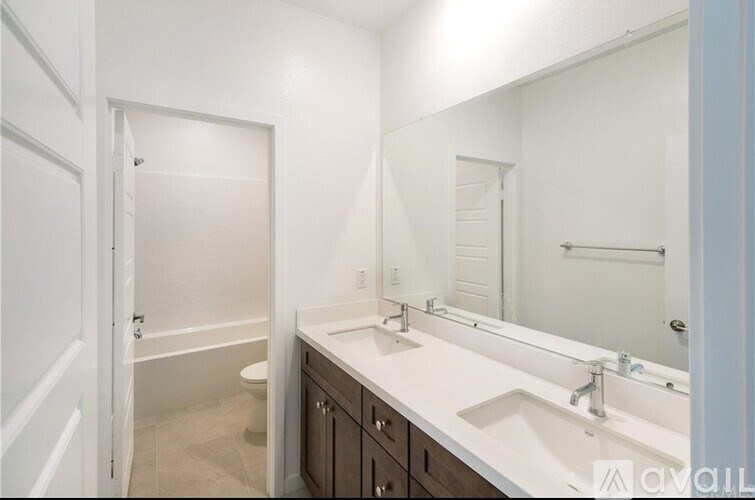 A bathroom with a white counter and a white sink.