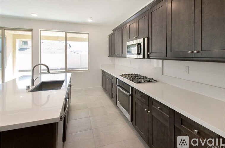 A kitchen with dark brown cabinets and white countertops.