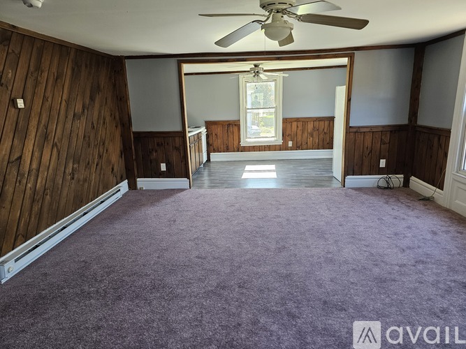 A room with a purple carpet and wooden walls.