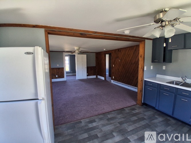 A kitchen with a white refrigerator and a ceiling fan.