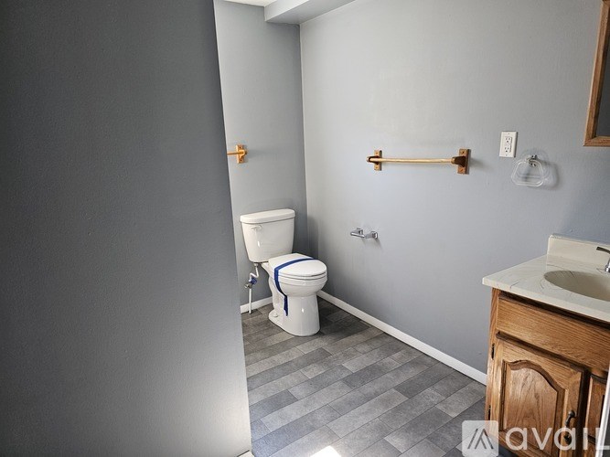 A bathroom with a toilet, sink, and a mirror.