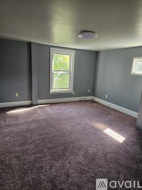 A room with a window and a carpet.