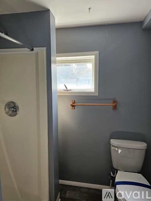 A bathroom with a toilet and a window.