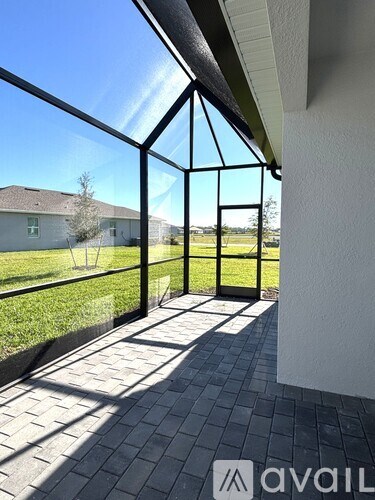 A patio with a black railing and tiled floor.