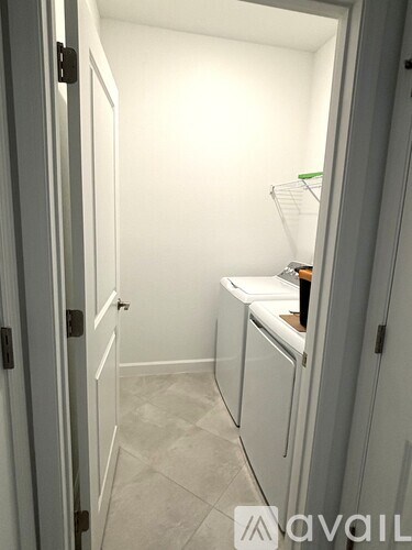 A small kitchen with white cabinets and a white door.