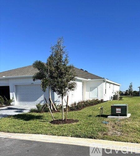A white house with a tree in front of it.