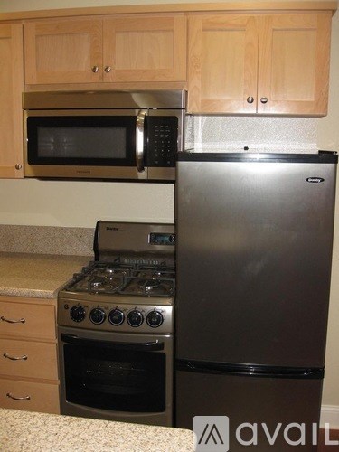 A kitchen with a stove, refrigerator, and microwave.