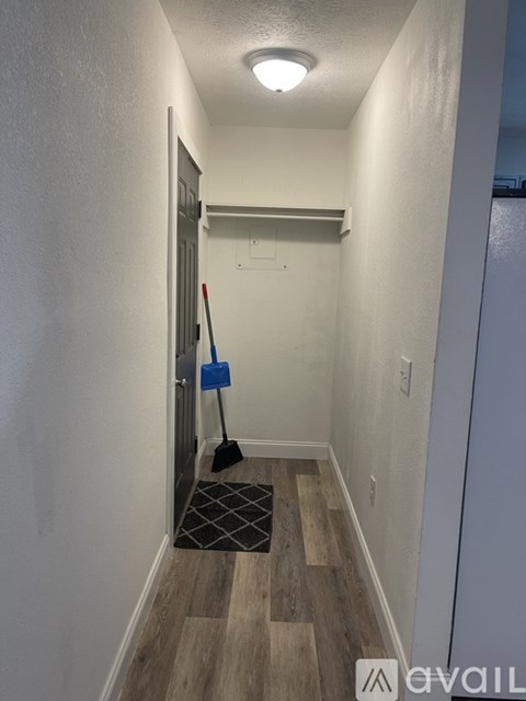 A broom is leaning against a wall in a hallway.