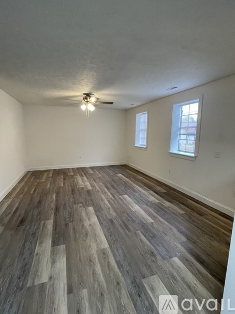 A room with wooden flooring and a ceiling fan.