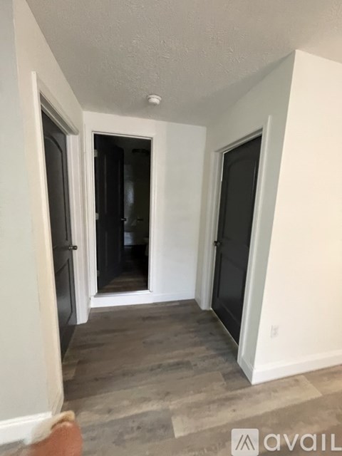 A hallway with a door on the left and a door on the right.
