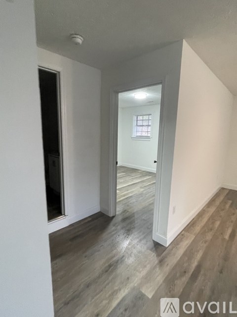 A room with wooden flooring and white walls.