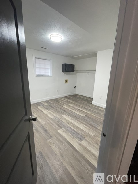 A room with wooden flooring and a black door.