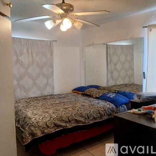 A bedroom with a bed and a ceiling fan.